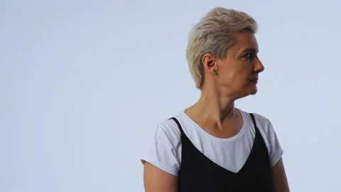 An irritated or distracted middle-aged woman looks sideways and looks at the Stock Footage 143603586