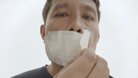 Irritated Thai man pull off a tape over mouth. Stock Footage 236398903