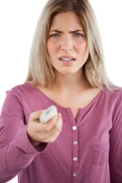 Irritated woman using remote control Stock Photos
