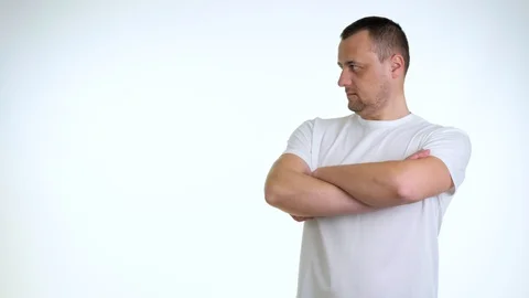 Irritated young guy in white t-shirt isolated on white background in studio Stock Footage 128132845