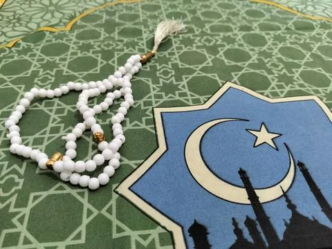 Islamic background concept featuring white prayer beads and a crescent moon Stock Photos