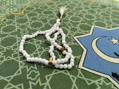 Islamic background concept featuring white prayer beads and a crescent moon  Stock Photos