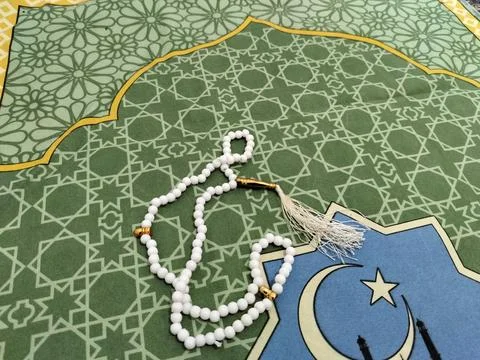 Islamic background concept featuring white prayer beads and a crescent moon  Stock Photos