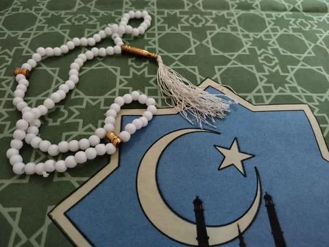 Islamic background concept featuring white prayer beads and a crescent moon  Stock Photos