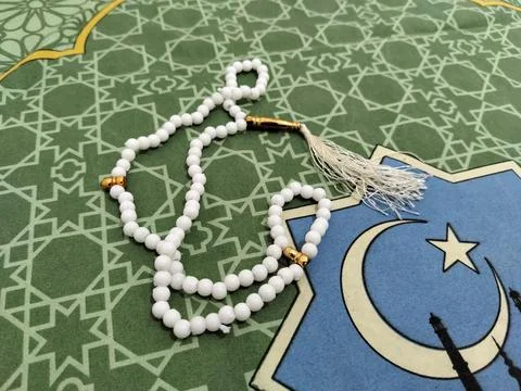 Islamic background concept featuring white prayer beads and a crescent moon  Stock Photos