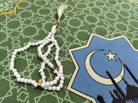 Islamic background concept featuring white prayer beads and a crescent moon  Stock Photos