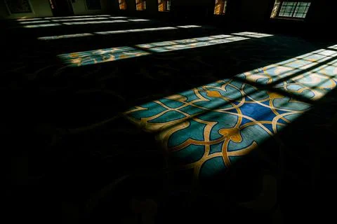 Islamic background. Shadows of window on the carpet in a mosque Stock Photos