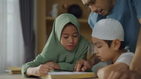 Islamic concept of 4k Resolution. Asian father teaching children to study Q.. Stock Footage 314910594