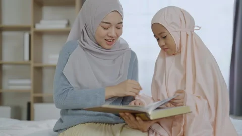 Islamic concept of 4k Resolution. Asian mother teaching daughter to study Q.. Stock Footage 314910619