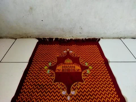 Islamic Prayer Mat with Mosque Pattern Laid on Tiled Floor 12 October 2026 Stock Photos