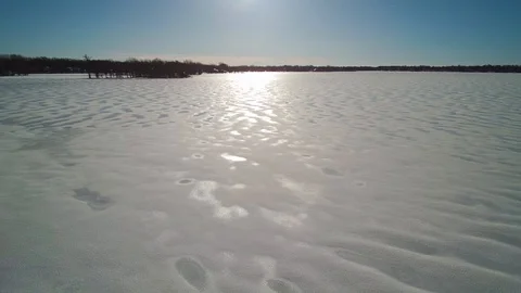 Island on frozen Mille Îles River, aerial winter landscape, blue sky Stock Footage
