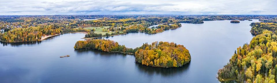 Island in the lake and forest in autumn colors. Golden trees and a blue water Stock Photos