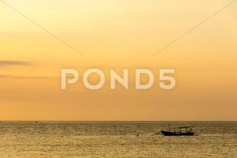 On the island Pulau Gili Meno, boat at sunset Stock Photos