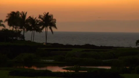 Island sunset over ocean overlooking palm trees and golf course putting gree Stock Footage 125332549
