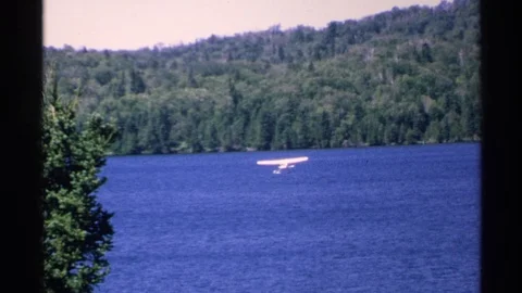 ISLE ROYALE MICHIGAN-1972: Floatplane Landing on Lake Near Pier with Waiting Stock Footage 125776442