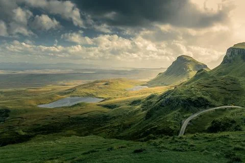 Isle of Skye's dramatic cliffs, green hills, and winding road under stormy skies Stock Photos