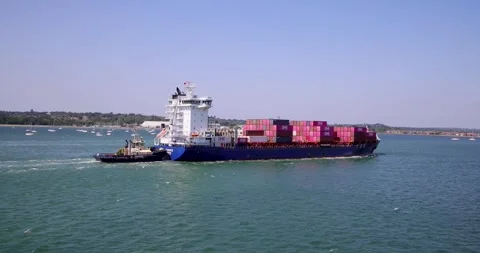 Isle of Wight England, 14th July 2026: Cargo container ship assisted by a t.. Stock Footage 340881353