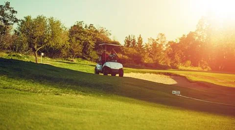 Isnt this where we got on. two golfers riding in a cart on a golf course. 스톡 사진