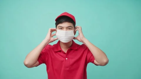 Isolate background of Asian delivery man wearing face mask to prevent covid-19. Stock Footage 164938557