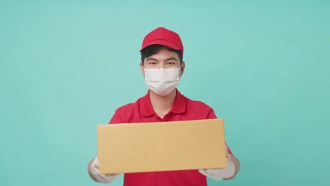Isolate background, Asian delivery man holding box on hands and giving ahead. Video stock 164938628