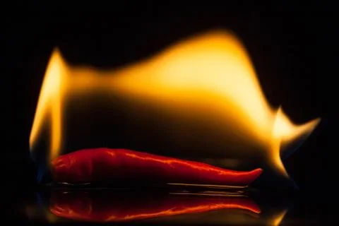 Isolate fire on red chilli on black ground Stock Photos