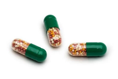 Isolate. Three separate green capsules with medicine on a white background. Stock Photos