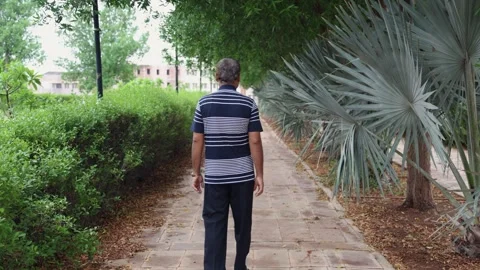 Isolated alone ill man walking at outdoor park at evening from different angl Stock Footage 282439095