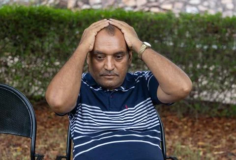 Isolated alone man in depression sitting at outdoor park at evening from fl.. 스톡 사진