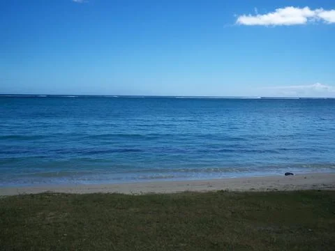 Isolated beach with clear sky and sea Stock Photos