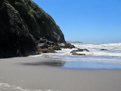 Isolated Beach Surrounded by Rocky Cliffs and Shoreline Stock Photos