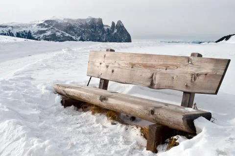 Isolated bench in snow scape Stock Photos