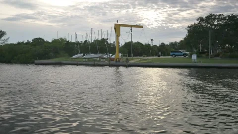 Isolated blue gray heron perched on two legs on top of yellow boat lift on the f Stock Footage 284049892