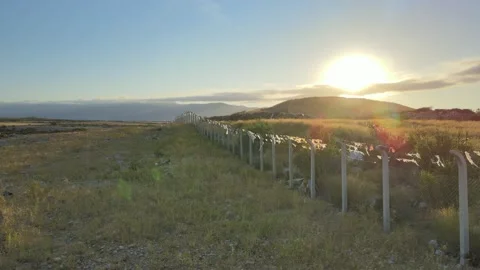 Isolated border fence barbed wire wall between countries at sunset. Drone 動画素材 158813017