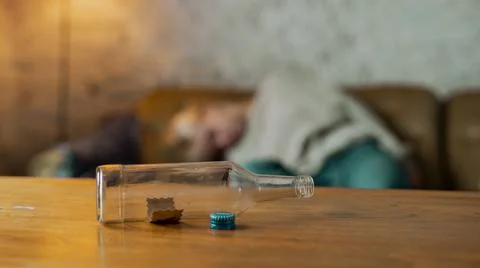 Isolated Bottle of Pills on the Table, While a Young Girl is Laying on the Sofa Stock Photos