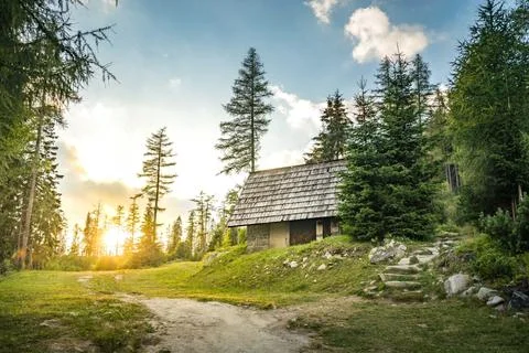 Isolated Cabin in Mountains Surrounded by Deep Forrest, sunset in background Stock Photos