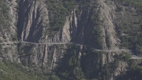 Isolated car driving on a mountain windy road from a distance Vídeo Stock 143775723