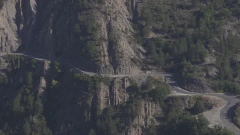 Isolated car driving on a mountain windy road from a distance Vídeo Stock 144098481