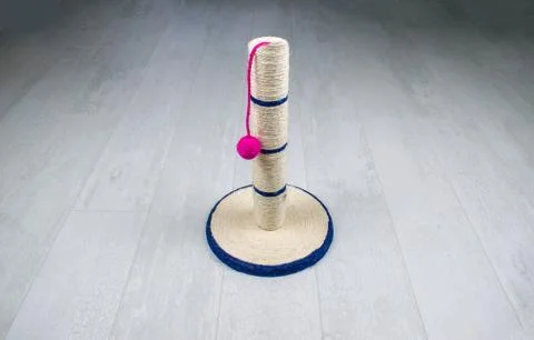 Isolated cat scratching post with ball toy on a wooden background. Stock Photos