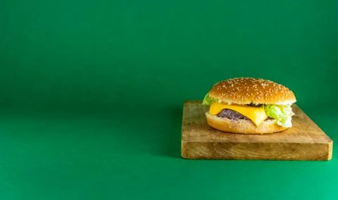 Isolated cheeseburger on green background Stock Photos