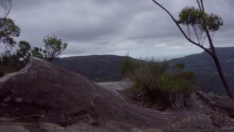 Isolated Cliff Face With Lone Trees Swaying, Southern Highlands, Australia Stock Footage 329364447