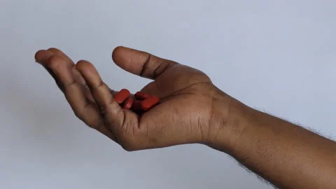 Isolated close shot of a black man's hand opening the fist filled with tablets Stock Footage 147096504