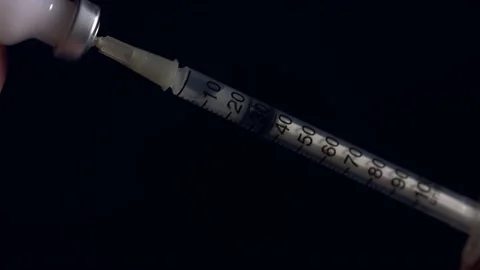 Isolated close up shot of a hypodermic needle being filled with a white Stock Footage 148212654