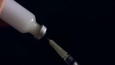 Isolated close up shot of a hypodermic needle being filled with a white Stock Footage 148212661