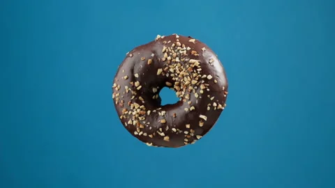 Isolated delicious donut rotating at blue background. Chocolate donut. Stock-Footage 163080935