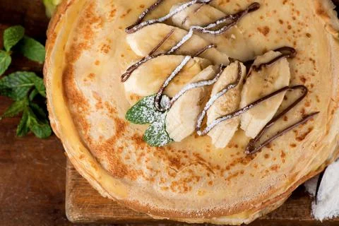 Isolated desert - stack of pancake with banana on a wooden table Stock Photos