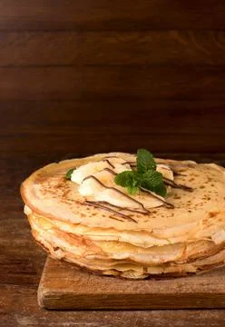 Isolated desert - stack of pancake with banana on a wooden table Stock-Fotos
