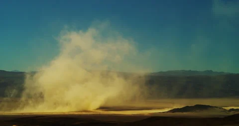 Isolated dust storm roars across a dry lake bed as it tears through Death Valley Stock Footage 268932373