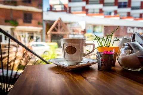 Isolated elegant cup of tea on a table of a cafe next to a window Stock Photos