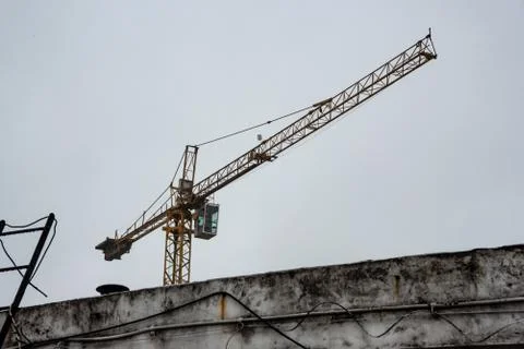 Isolated empty construction crane on a cloudy and rainy day Stock Photos