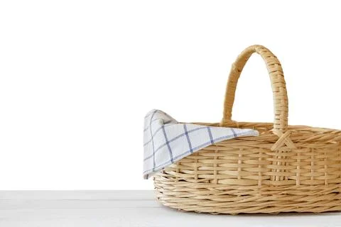 Isolated empty wicker basket on white wooden table. Template mock up Фото
